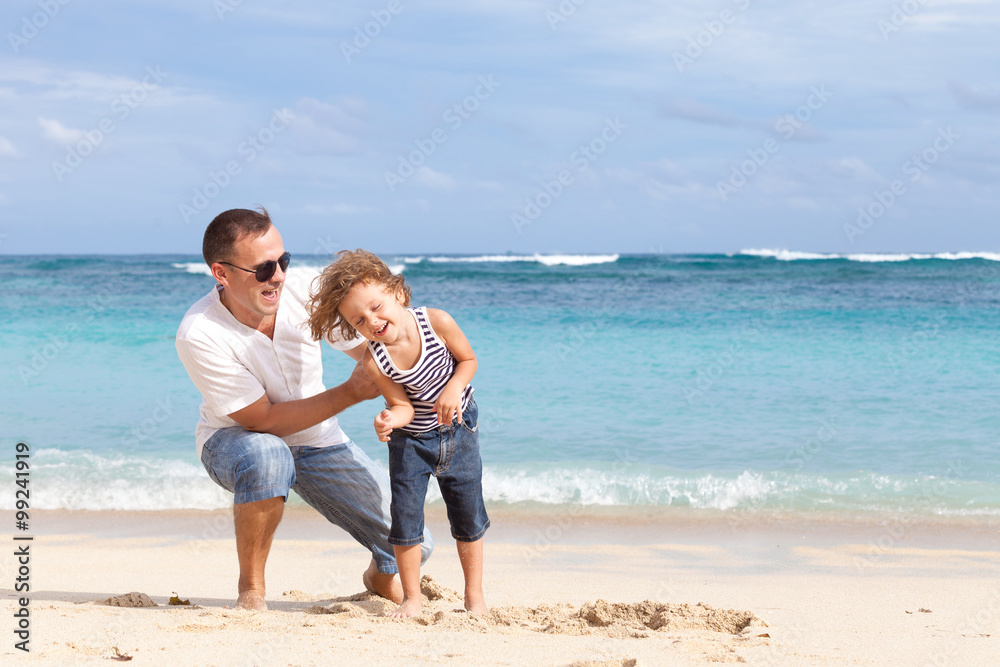 Happy father and son playing on the beach at the day time.