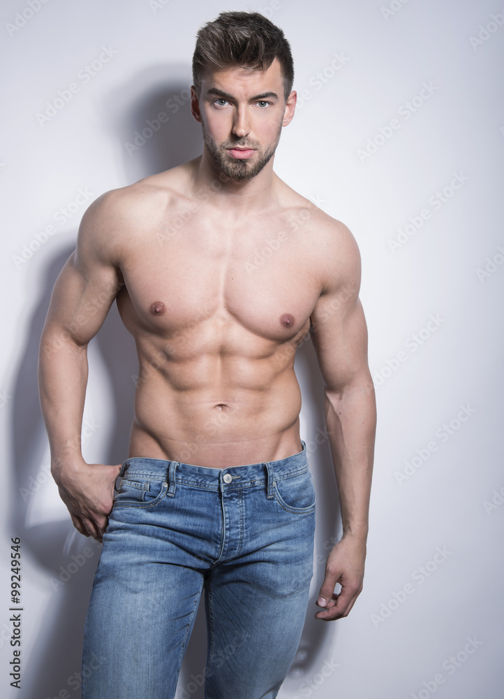 handsome young bodybuilder with toned body posing shirtless