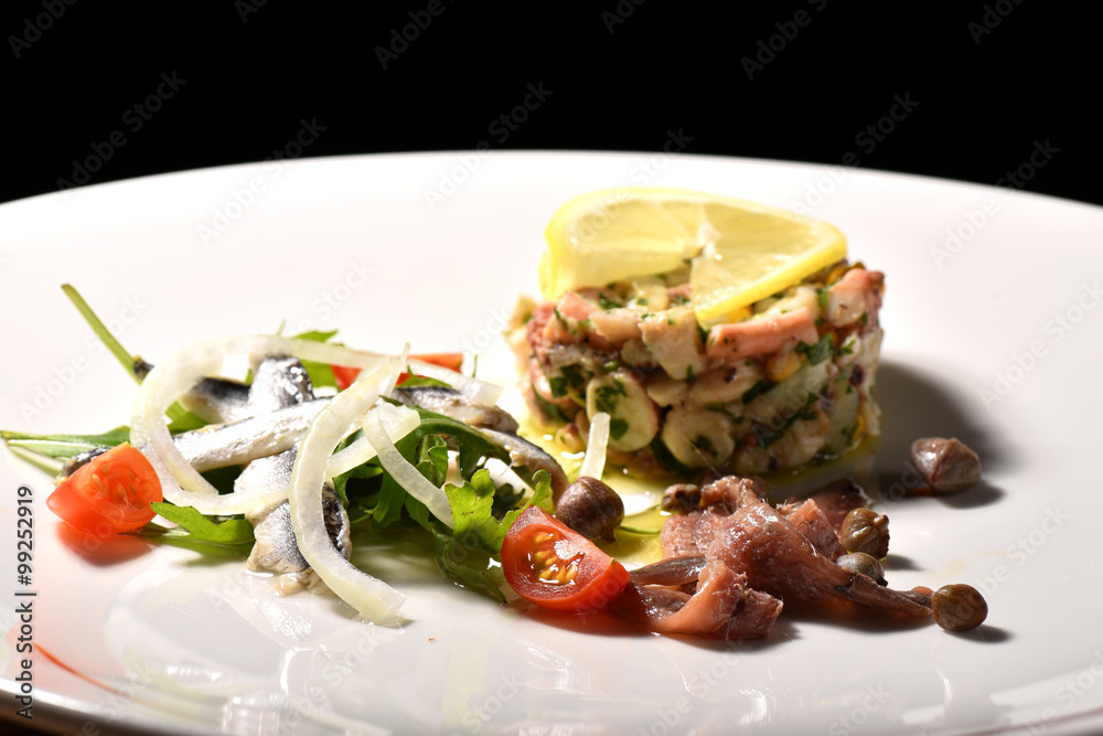 Fine dining seafood appetizer with Anchovies and octopus salad