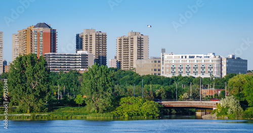 Ottawa River and capitol city skyline along the parkway - late springtime afternoon - early evening approaches. Tall buildings, apartments and condominiums comprise an Ottawa city skyline.