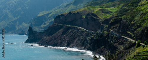 Black coastline road with houses on green cape verde island 