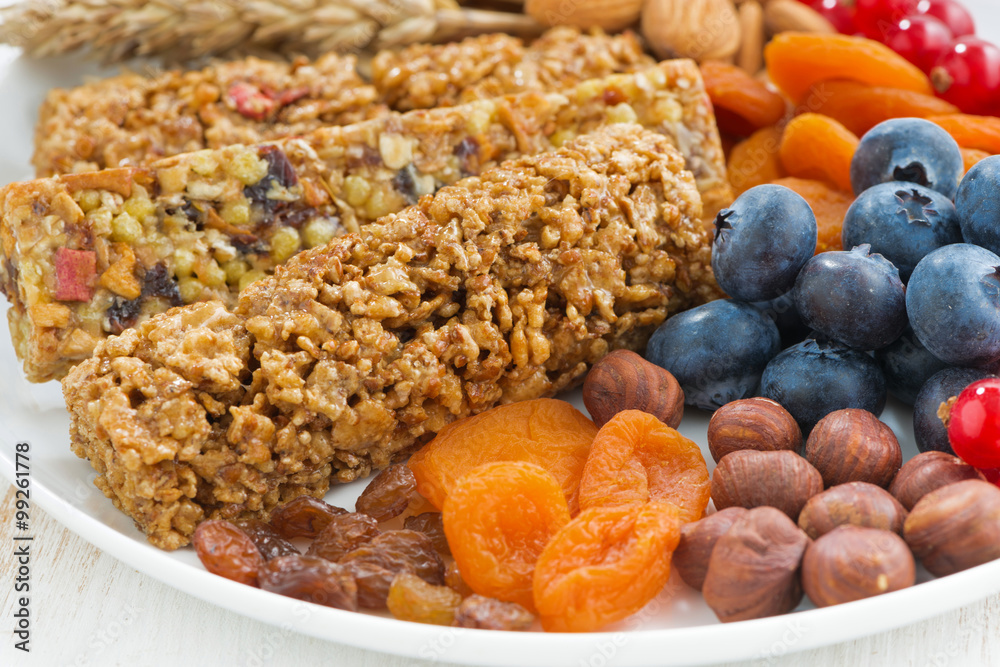 cereal muesli bars, fresh and dried fruit on a white plate cereal muesli bars, fresh and dried fruit on a white plate
