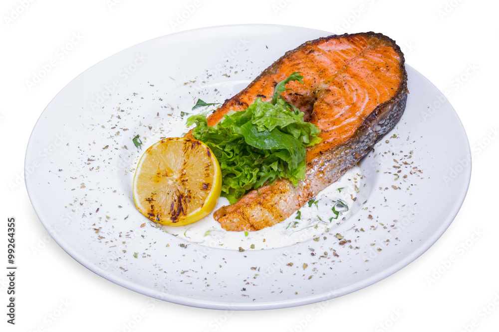 Grilled salmon steak with spinach in white plate, top view Grilled salmon steak with spinach in white plate, top view
