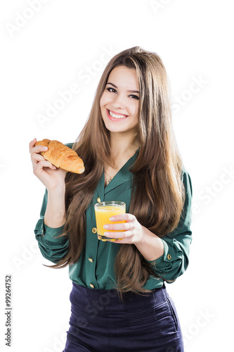 Obraz na plátne Young woman with glass of juice and croissant