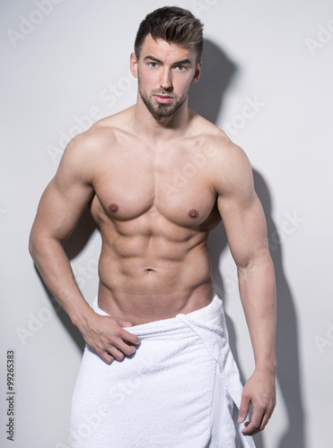 handsome young bodybuilder with toned body posing shirtless