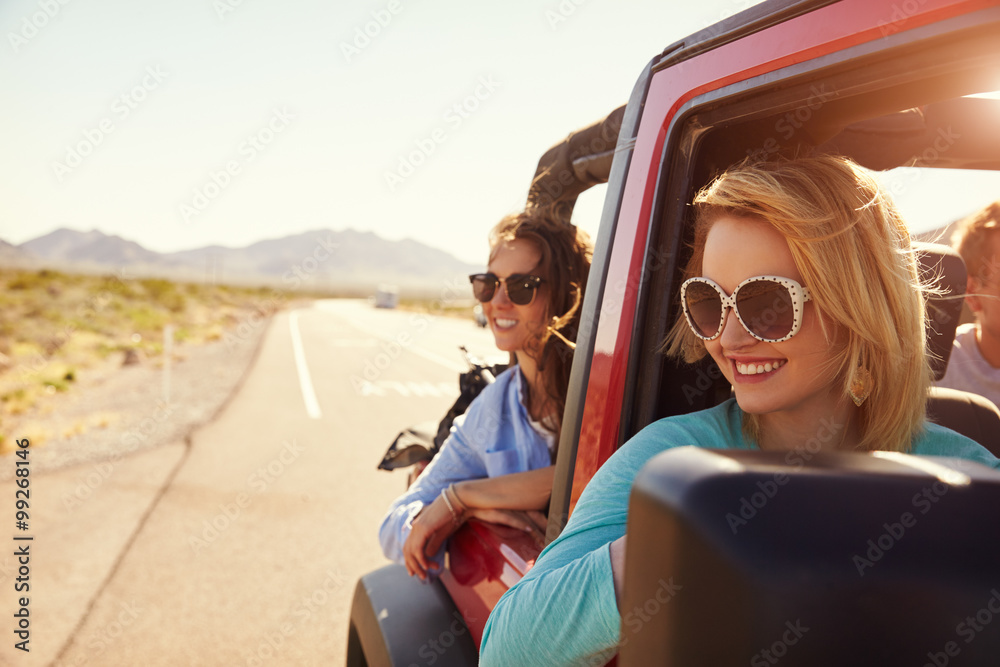 Female Friends On Road Trip In Back Of Convertible Car - obrazy, fototapety, plakaty 