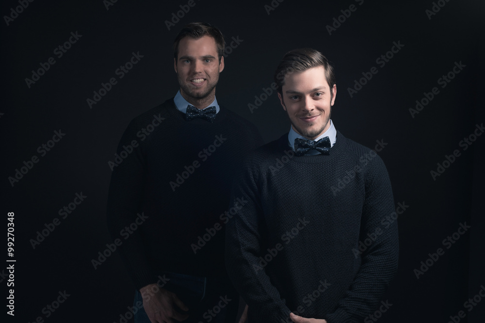 Obraz premium Two smiling men in dark blue sweater with shirt and bow tie.