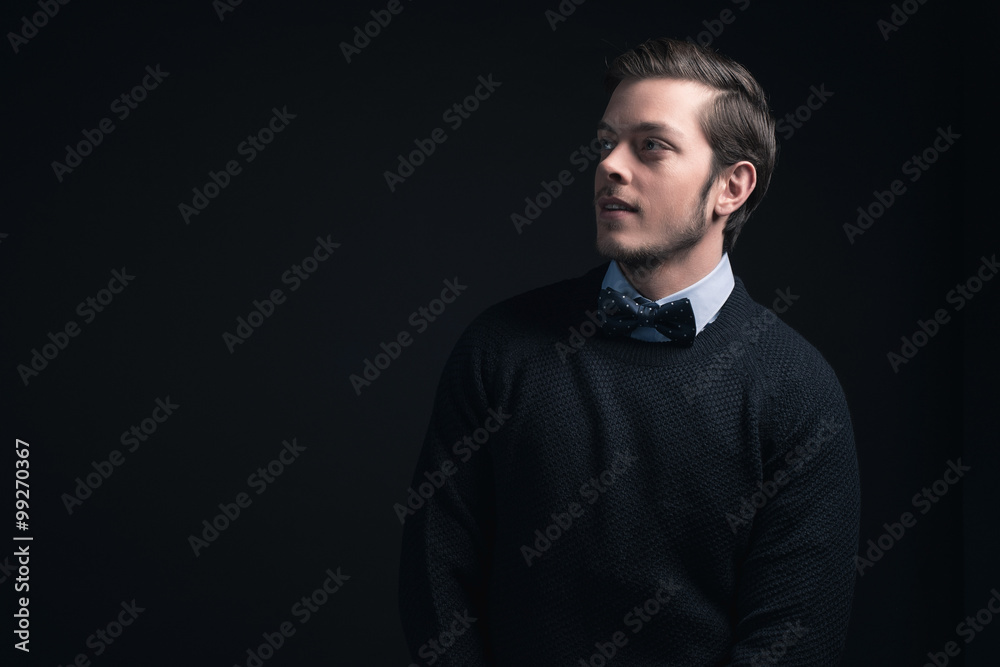Man wearing dark blue sweater and light blue shirt with bow tie.