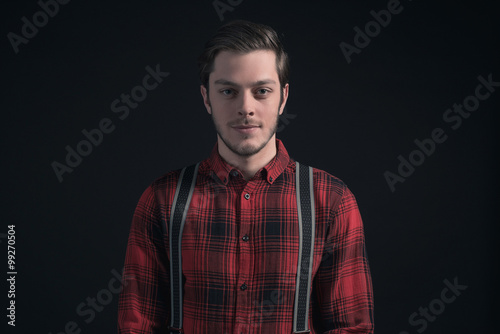 Fashionable man in red checkered shirt and braces.