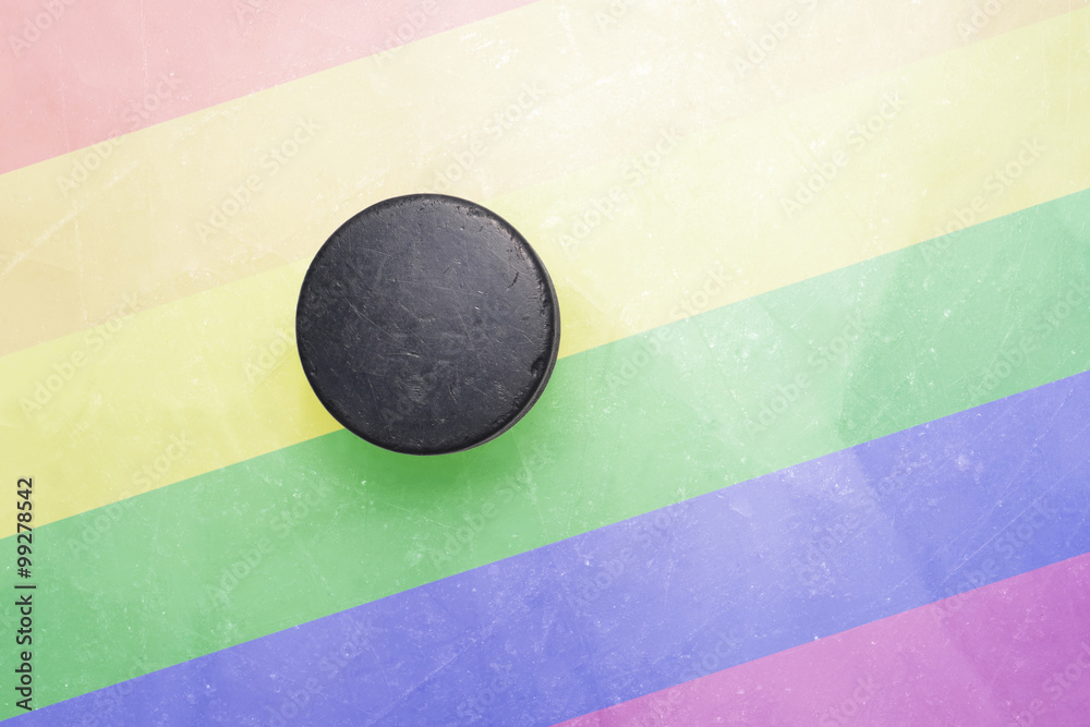 Fototapeta premium old hockey puck is on the ice with gay flag
