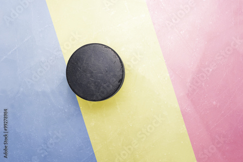 old hockey puck is on the ice with romania flag