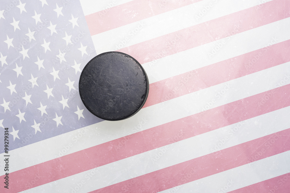 Obraz premium old hockey puck is on the ice with united states of america flag