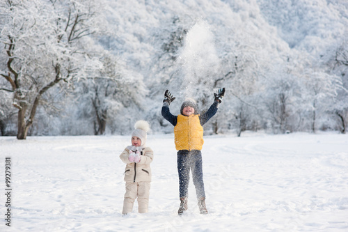 boy throws snow above the head being near the girl