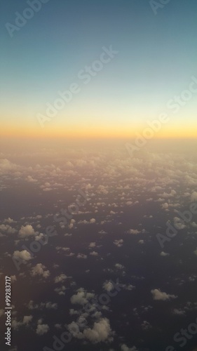 Flying over the ocean. Beautiful sunrise view from the airplane window.