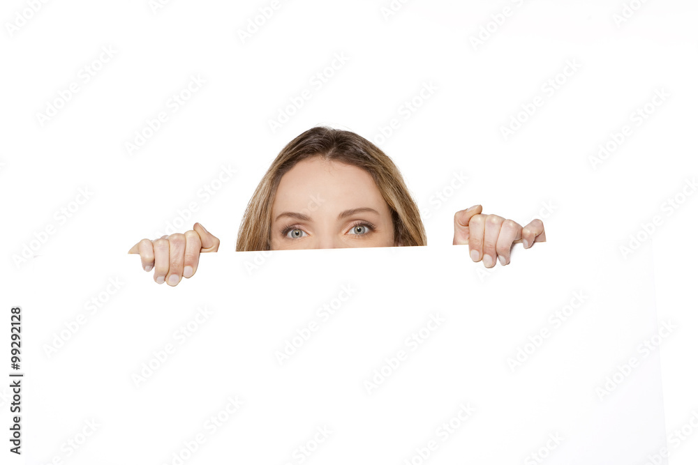 Behind a white board - Woman hiding or peeking behind a white sign Behind a white board - Woman hiding or peeking behind a white sign