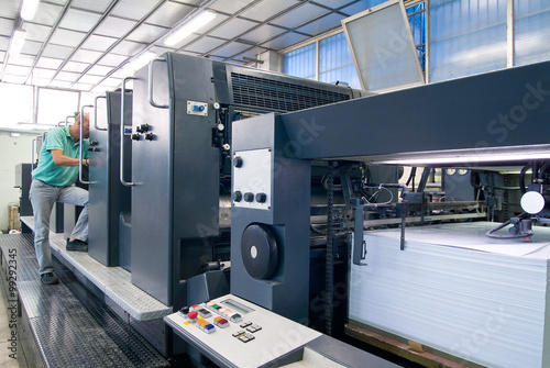 Operatore controlla stampante industriale a 5 colori