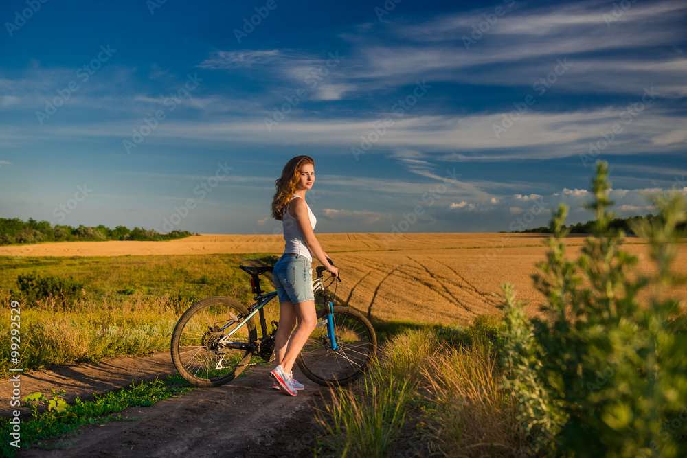 Young blond girl on the background of the rural landscape Young blond girl on the background of the rural landscape