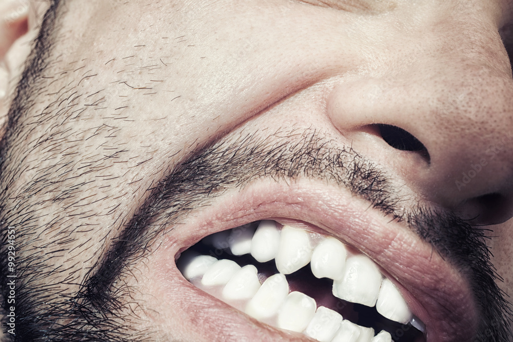 Fototapeta premium Male mouth with bared teeth close-up