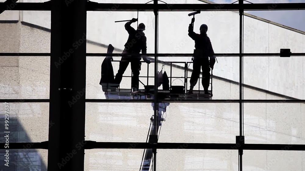 Two silhouette washers washing windows. Industrial climbers, facade cleaning 
