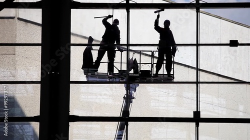 Two silhouette washers washing windows. Industrial climbers, facade cleaning 