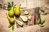 Sliced pears on old chopping board with leaves .