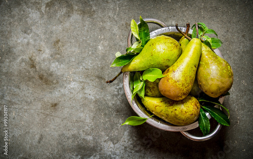 Fresh pears in the bowl with the leaves.