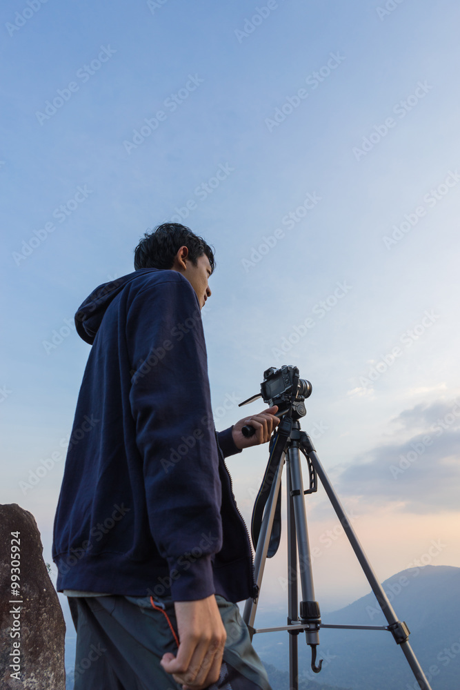 Camera man taking photo on the mountain when sunset