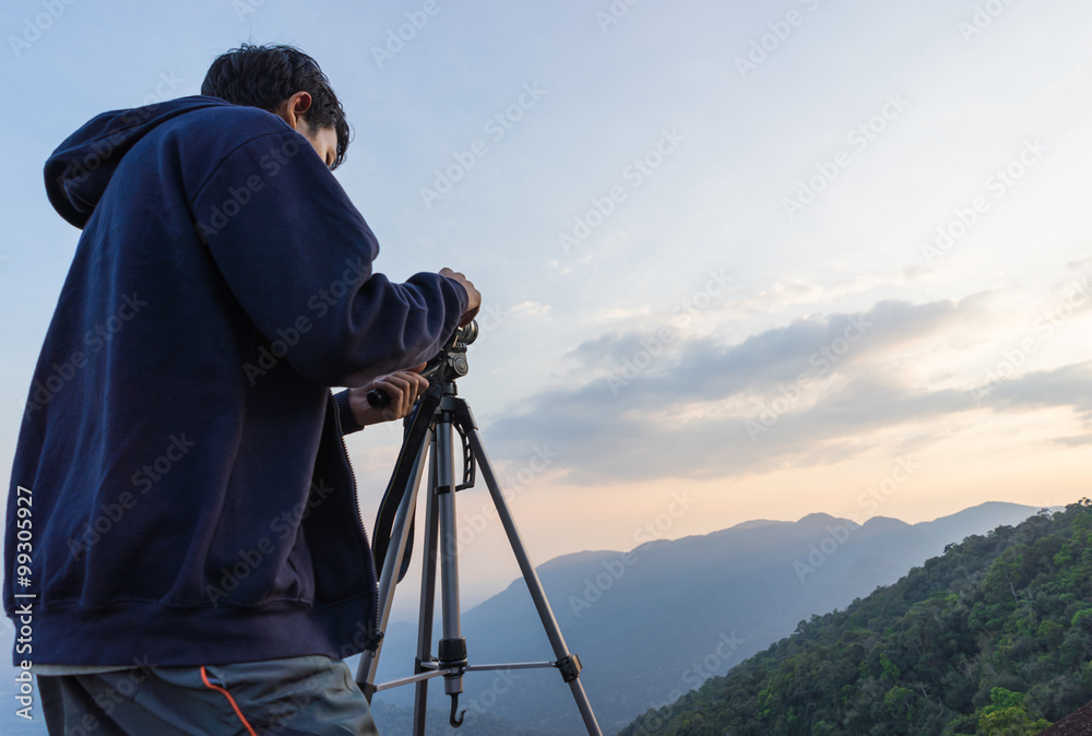 Camera man taking photo on the mountain when sunset