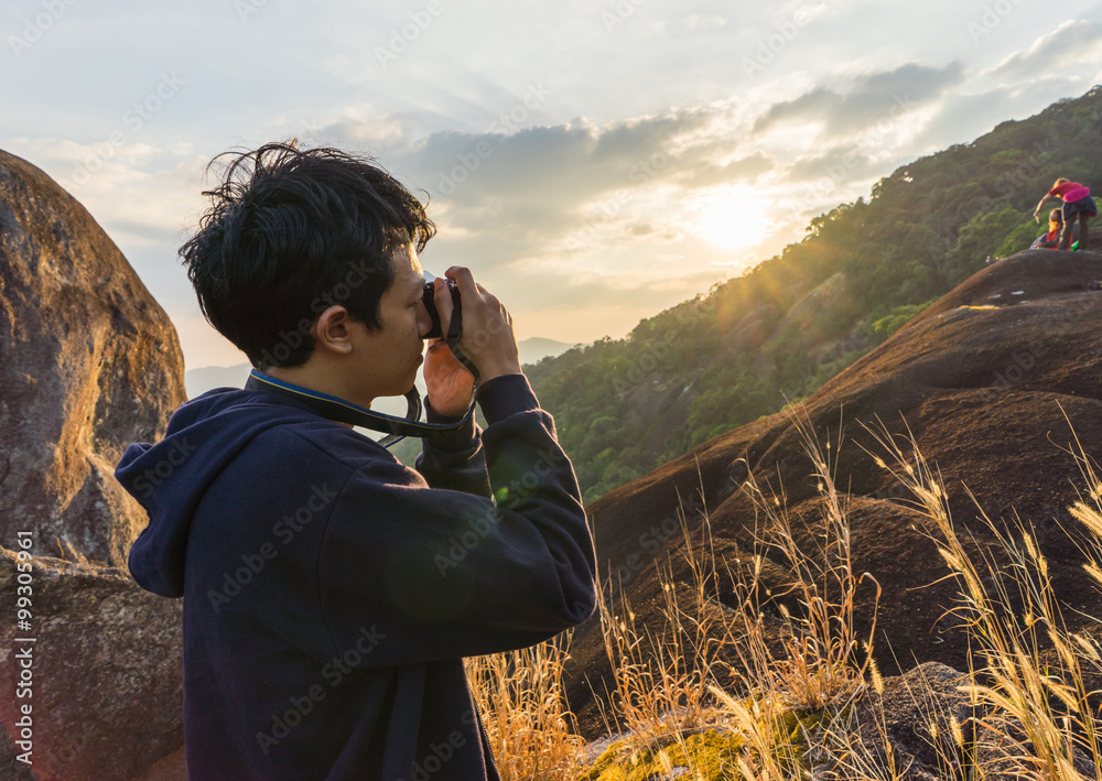Man taking photo on the mountain when sunset