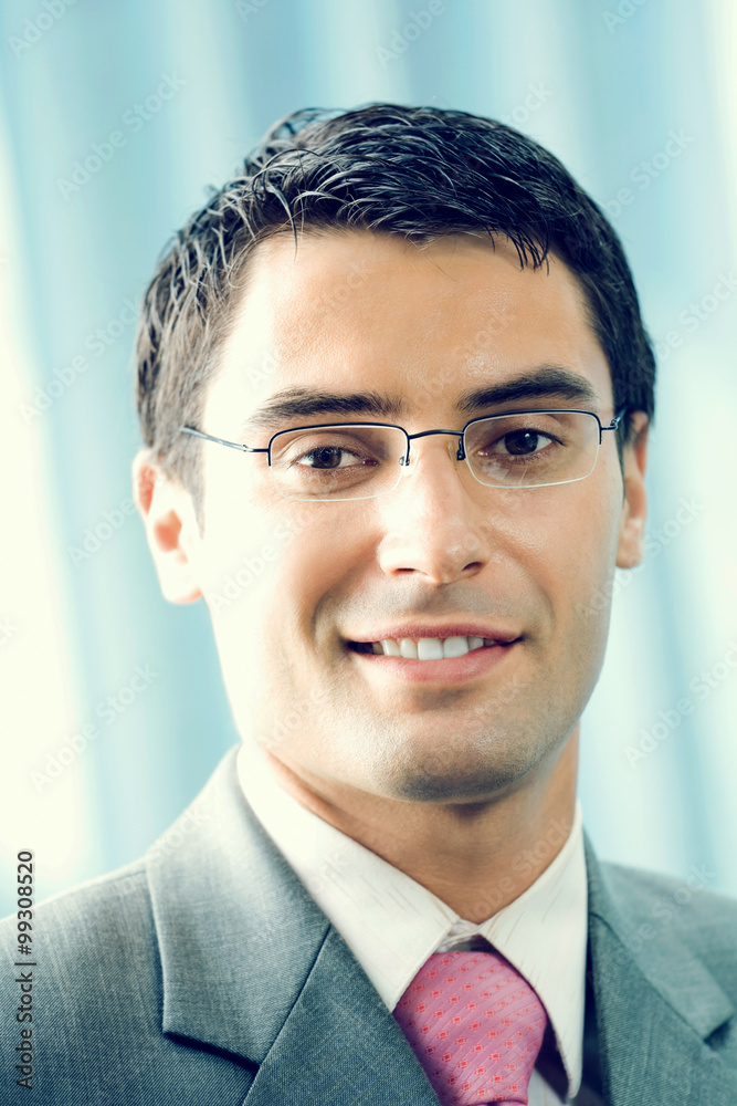 Portrait of happy smiling businessman at office