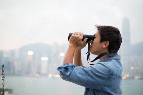 Man looking though the binocular at Hong Kong
