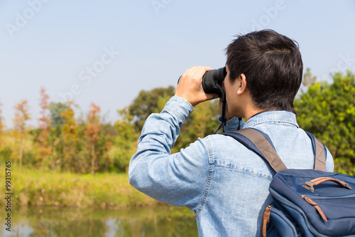 The back view of Man use of the binocular