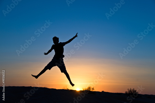 Silhouette of a boy jumping in the sun