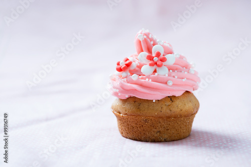 Veganer Cupcake mit Himbeerfrosting und Blütendekor