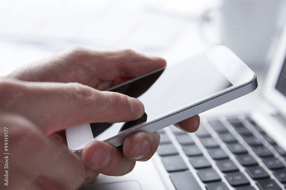 Person using phone while working on a Laptop Person using phone while working on a Laptop