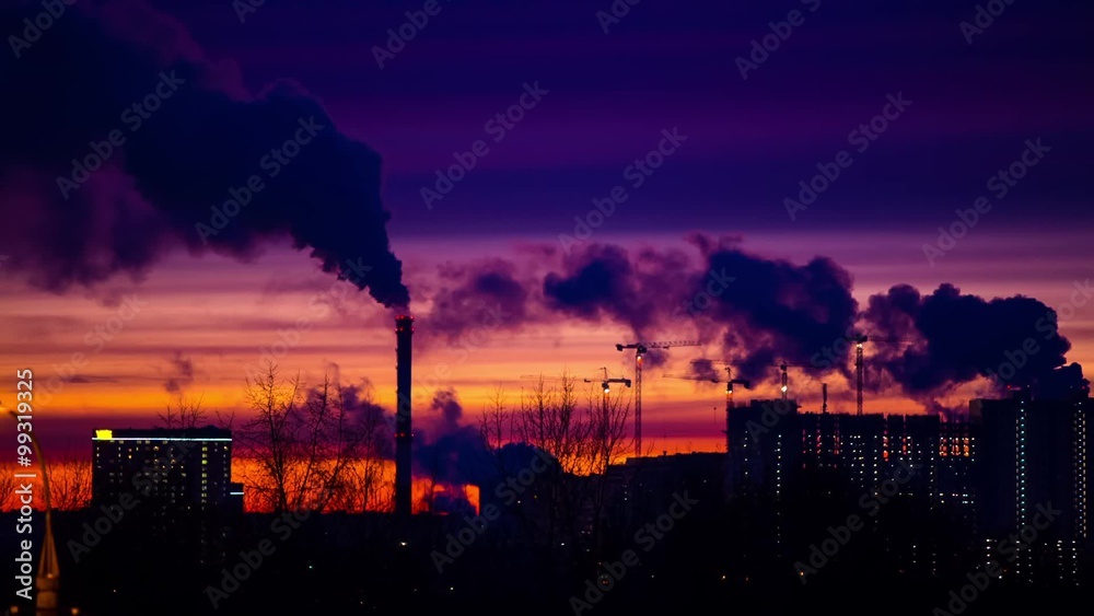 Modern city in the evening at sunset. Smoke comes out of the pipes of power plants and factories of the modern neighborhood on the outskirts of the metropolis. Urbanization. Modern city in the evening at sunset. Smoke comes out of the pipes of power plants and factories of the modern neighborhood on the outskirts of the metropolis. Urbanization.