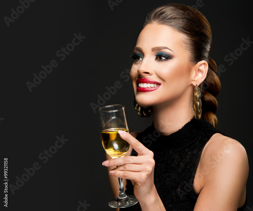 Beautiful woman celebrating with champagne; dark background 