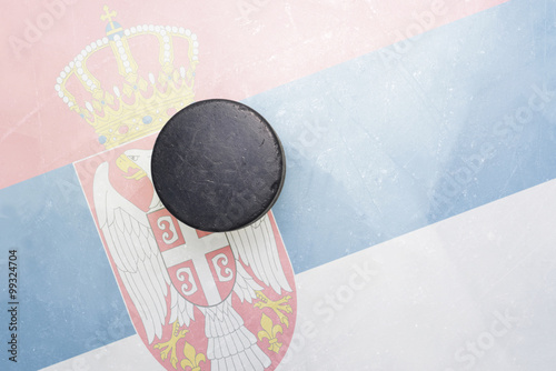 old hockey puck is on the ice with serbia flag