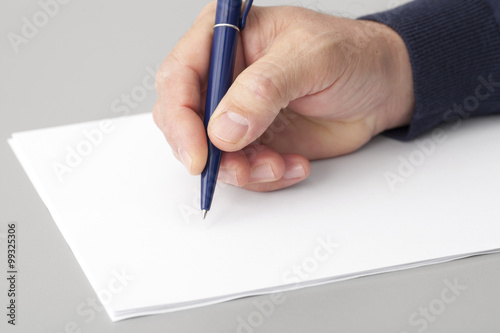 Human hand with a pen writing on a white clean sheets. 