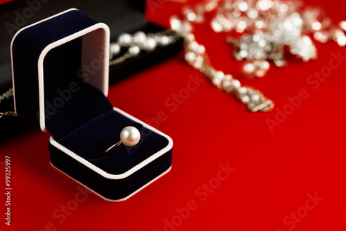 luxury ring and stylish necklace and gift box on red background, © sonyachny