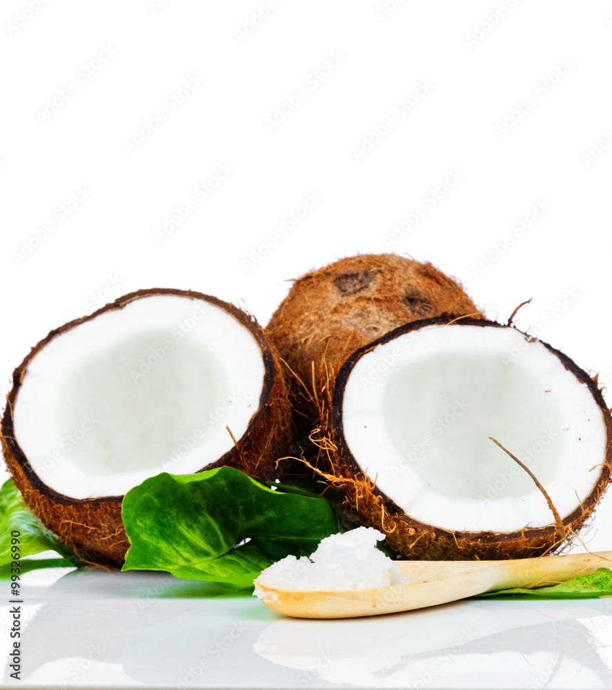 Coconuts with green leaves and a wooden spoon Coconuts with green leaves and a wooden spoon