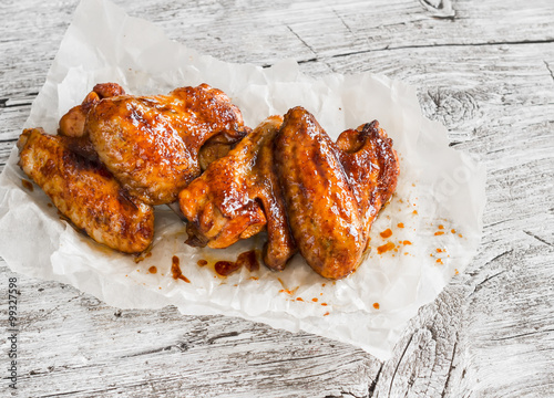 Spicy baked chicken wings on wooden rustic table