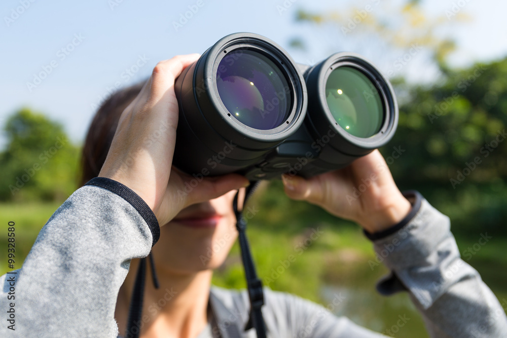 Young woman using binocular for bird watching Young woman using binocular for bird watching
