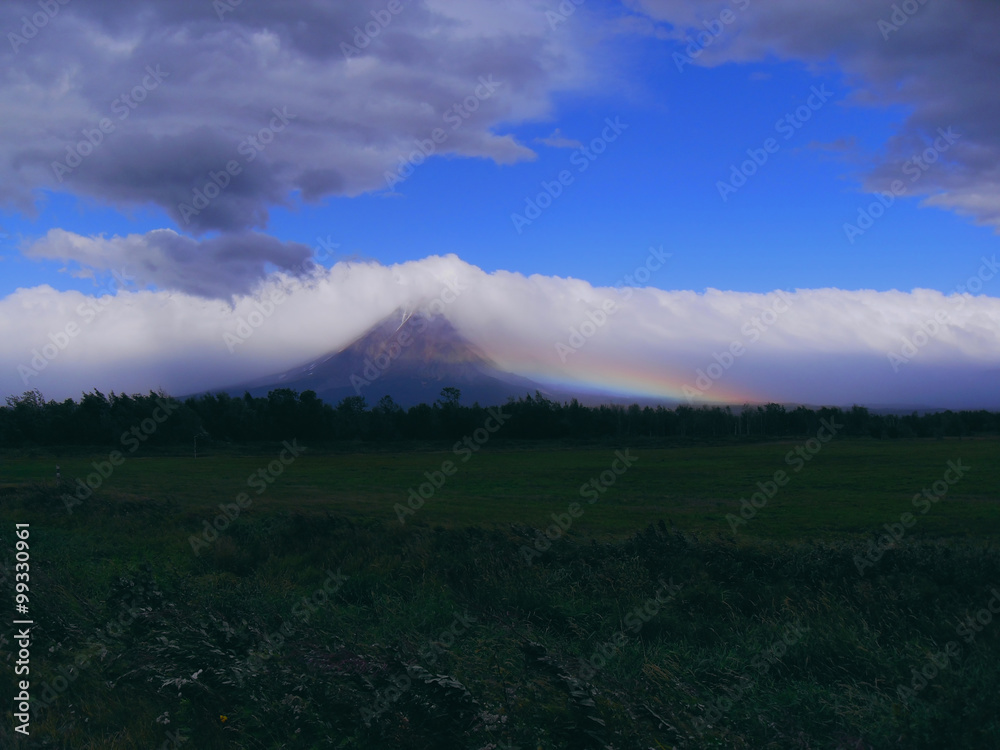 Fototapeta premium После бури. Буря почти кончилась, ветер еще дует, а рядом с вулканом возникла радуга.