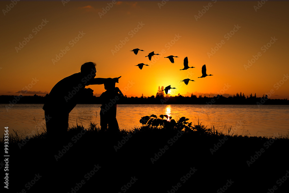 silhouette father and son play binoculars sunset background