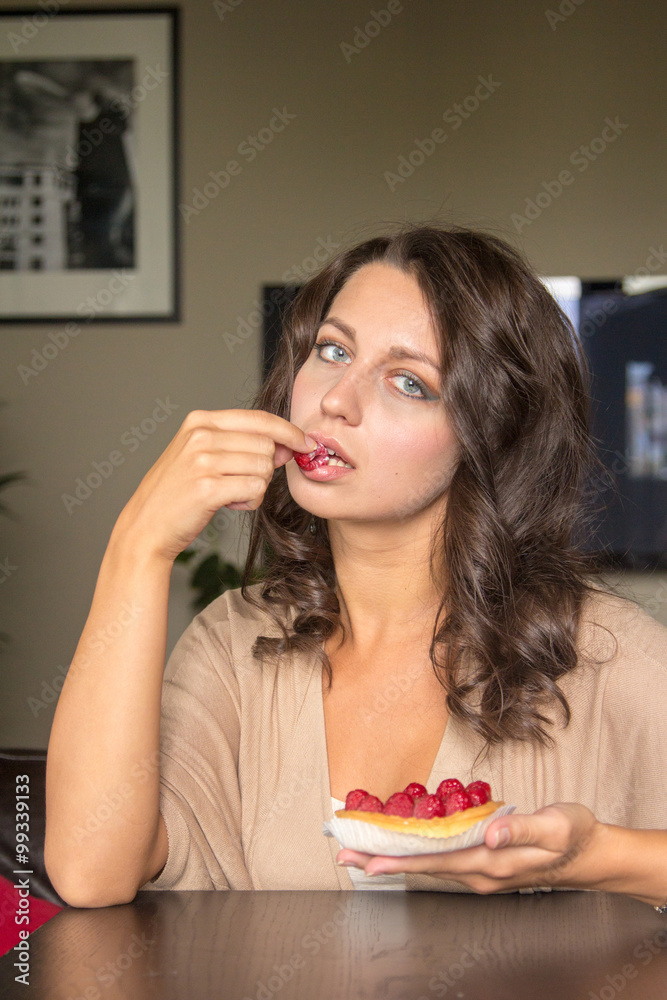 Woman eating cake with raspberry at home Woman eating cake with raspberry at home