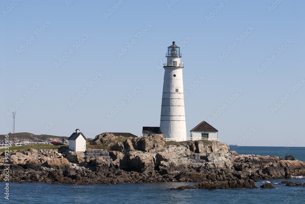 Historic Boston Harbor lighthouse on a summer day invites tourists to explore the beacon. It is the oldest lighthouse in America.