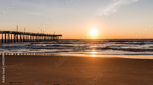 Virginia Beach  Virginia boardwalk fishing pier with the sun at the horizon.