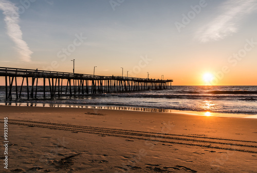 Virginia Beach, Virginia boardwalk fishing pier and beach at dawn. 