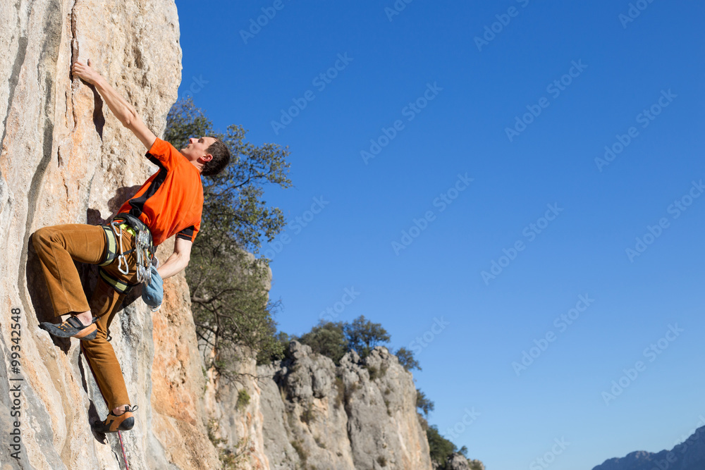 Young male climber hanging by a cliff. Young male climber hanging by a cliff.